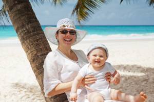 mom and happy baby on a beach