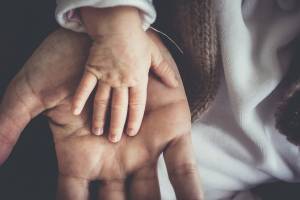 dad holding the hand of his toddler