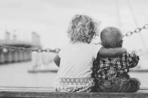 siblings sitting on a dock