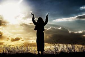 woman raising hands towards the sky in celebration